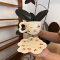 Detailed close-up of handmade floral ceramic coffee cup with irregular heart handle - Red Floral Cup And Saucer / Cup And Saucer
