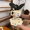 Macro detail of a floral ceramic coffee cup set with a wavy handle and petal saucer - Blue Floral Cup And Saucer / Cup And Saucer