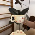 Detail of cream ceramic coffee cup and cloud saucer set with hand-painted cherry patterns - Red Floral Single Cup / Cup