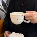 Handmade wavy cream ceramic mug and saucer set with red hearts held by a person - Little Heart Cloud Single Cup 300ml