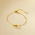 Elegante bracciale dorato con ciondolo a doppio cuore e chiusura a moschettone - Oro