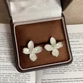 Detailed close-up of shell petal flower earrings on a velvet jewelry box - Four Petal Mica Texture Style / Silver