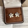 Macro shot of French style shell flower earrings with zircon details in a jewelry box - Rhinestone Edged Flower Style / Silver