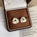 Elegant silver triangle stud earrings with white shell inlay in a leather jewelry box - Triangle Crushed Shell Style