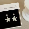 Elegant star-shaped drop earrings with white shell inlay and sparkling crystals - Star Drop Pearlescent Style