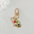 Detail view of golden cat keychain with colorful dried flowers and resin filling - Red & Green Flower Cat
