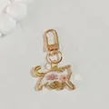 Close-up of golden cat keychain pendant with delicate pink dried flowers inside - Light Pink Flower Cat