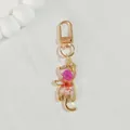 Close-up detail of a cat-shaped resin keychain featuring vibrant pink dried flowers - Peach Pink Flower Cat