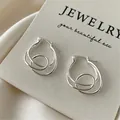Elegant silver-toned irregular geometric swirl hoop earrings with secure buckle closure - Spiral Geometric Style / Silver