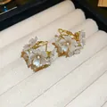 Elegant gold flower hoop earrings with white pearls presented in a cream jewelry tray - White Flower Gold Drop Studs (29#)