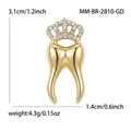 Vue détaillée de la broche en forme de dent avec couronne dorée et strass brillants. - Or (MM-BR-2810-GD)