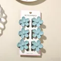 Set of six matte light blue plumeria flower hair claw clips on white display card - Five-Petal Flower / 6-Piece Set (With Card) / Matte Haze Blue
