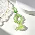 Dettaglio portachiavi a balena verde traslucida con perline glitterate e gancio. - Verde