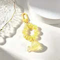Close-up of yellow translucent whale keychain with sparkling beaded chain accessory - Yellow