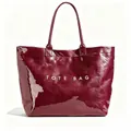 Glossy burgundy DuPont paper tote bag detail with white TOTE BAG text print. - Burgundy