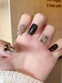 Detail of press-on nails with black and nude colors, polka dots, and cat-themed bow design - M / Black Cat Bowtie Style (BY1574)