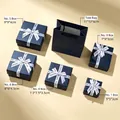 Comparison of various sizes of navy blue jewelry gift boxes with bow ribbons. - Navy Blue Letter Style
