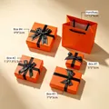 Orange jewelry gift boxes in various sizes with decorative black ribbons - Starlight Orange Style