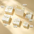 Detailed view of cream jewelry gift box set in various sizes with gold ribbon bows - Cream White (Gold Edge)