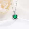 Macro shot of silver perfume bottle pendant with green zircon and pavé stone settings - Emerald