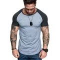 Αθλητικό ανδρικό μπλουζάκι slim fit με γκρι σώμα και μαύρα ανάγλυφα μανίκια ραγλάν - M / Ανοιχτό Γκρι με Μαύρο