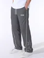 Close-up view of gray men's sports pants featuring side piping and star embroidery details - Dark Gray