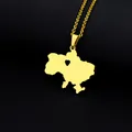 Detail of gold Ukraine map necklace with a hollow heart on a textured black surface - Map Heart Style (金色项链K) / Gold