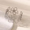 Detailed macro shot of a silver hollow daisy flower cuff bracelet with a textured metal finish. - Hollow Out Daisy Bangle (B1737) / Silver
