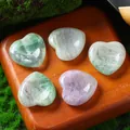 Assorted 30mm natural fluorite crystal heart-shaped worry stones on wooden display - 30MM / Green Fluorite