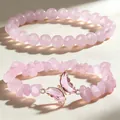 Vista ravvicinata di un set di braccialetti in quarzo rosa con ciondolo a farfalla - Quarzo Rosa