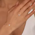 Elegante bracciale con anello in oro rosa e foglie di zircone sulla mano di una modella - Stile Foglia / Oro