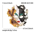 Ornate enamel masquerade mask brooch with golden leaf detailing and size markings - KC Gold Yellow Black White