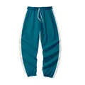 Detail of dark teal kids' sports joggers with side stripes and white drawstring - Size 110 / Single Sweatpants / Cyan Blue