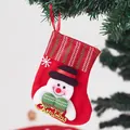Red Christmas stocking featuring a smiling snowman applique and gold glitter text - Striped Snowman