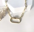 Gros plan d'un collier en acier inoxydable doré avec un grand fermoir mousqueton. - Or