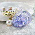Clear purple purse-shaped acrylic keychain with sparkly stars and elegant pearl charm - Noctilucent TV Style / Purple