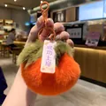 Close-up of soft orange plush persimmon keychain featuring a success blessing tag - Persimmon Successful Pass