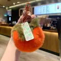 Detailed view of an orange plush persimmon keychain with a green leaf and success tag. - Persimmon Success Upon Arrival