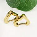 Close-up view of golden geometric triangle hoop earrings made of polished titanium steel - Heart Shape Gold (Single Piece)