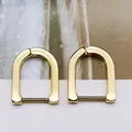 Macro detail view of elegant gold-plated minimalist U-shaped hoop earrings on background - Large U-shape Gold (Single Piece)