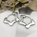Detailed view of silver star-shaped titanium steel hoop earrings on white cloth - Four-pointed Star Steel Color (Single Piece)