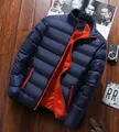 Detail view of navy blue puffer jacket featuring horizontal quilting and bright orange lining - M / Navy Blue Contrast Orange