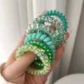 Detail view of colorful spiral telephone wire hair ties in various green shades - OPP Bag Style / Green