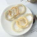 Detailed view of assorted colorful spiral telephone wire hair ties on a white plate - OPP Bag Style / Yellow