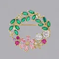 Elegante spilla a ghirlanda floreale con foglie verdi e cristalli rosa con finitura dorata - Ghirlanda in Zircone Colorato