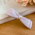 Nahaufnahme einer rosa Satin-Schleifen-Haarklammer mit eleganten Perlen und Perlenmitte. - Entenschnabel-Clip - Perlenstil / 1 Stück / Rosa