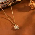 Detailopname van gouden lotus hanger met parel op een bruine getextureerde grond. - Parel Strass Bloem Stijl(T069) / Ketting / Goud