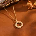 Detailweergave van een goudkleurige ronde hanger ketting met parels en kristallen. - Multi-Parel Ring Stijl(T069) / Ketting / Goud
