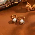 Detalle de elegantes pendientes de aro con perlas barrocas y base en espiral dorada - Pendientes (T069 Oro Línea Negra)