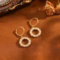 Primer plano de pendientes de aro dorados con perlas y cristales sobre marrón. - Pendientes (T069 Oro Anillo Multi-Perlas)